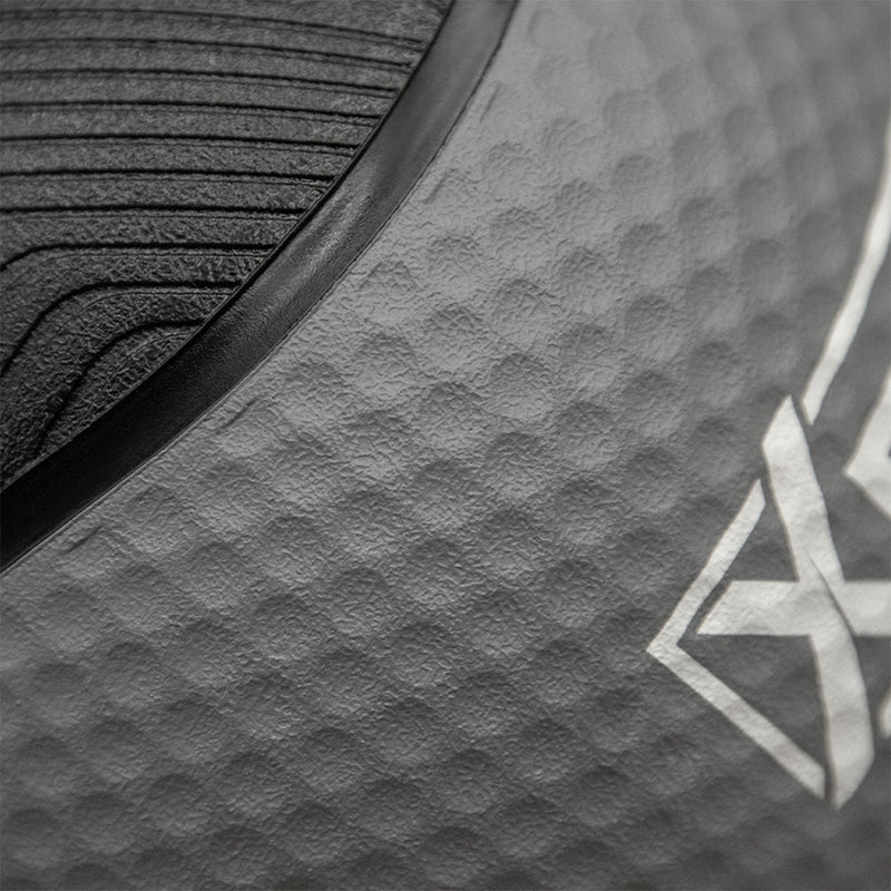 Close-up of a dark gray textured athletic surface with a black curved trim and a partial white geometric logo.